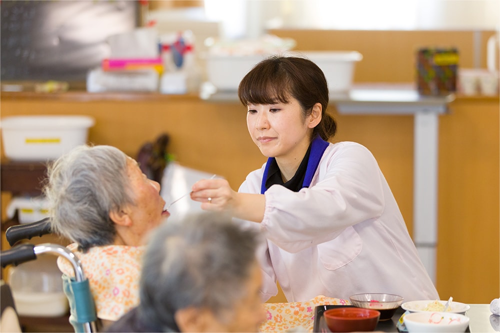 食事の補助をする介護士の写真