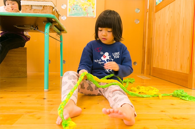 ひもで遊ぶ子ども