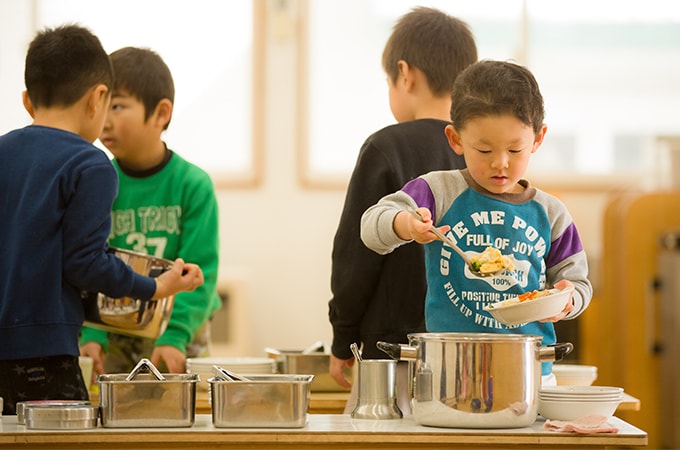 給食を盛り付けている子どもの写真