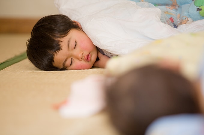 お昼寝をする子どもの写真